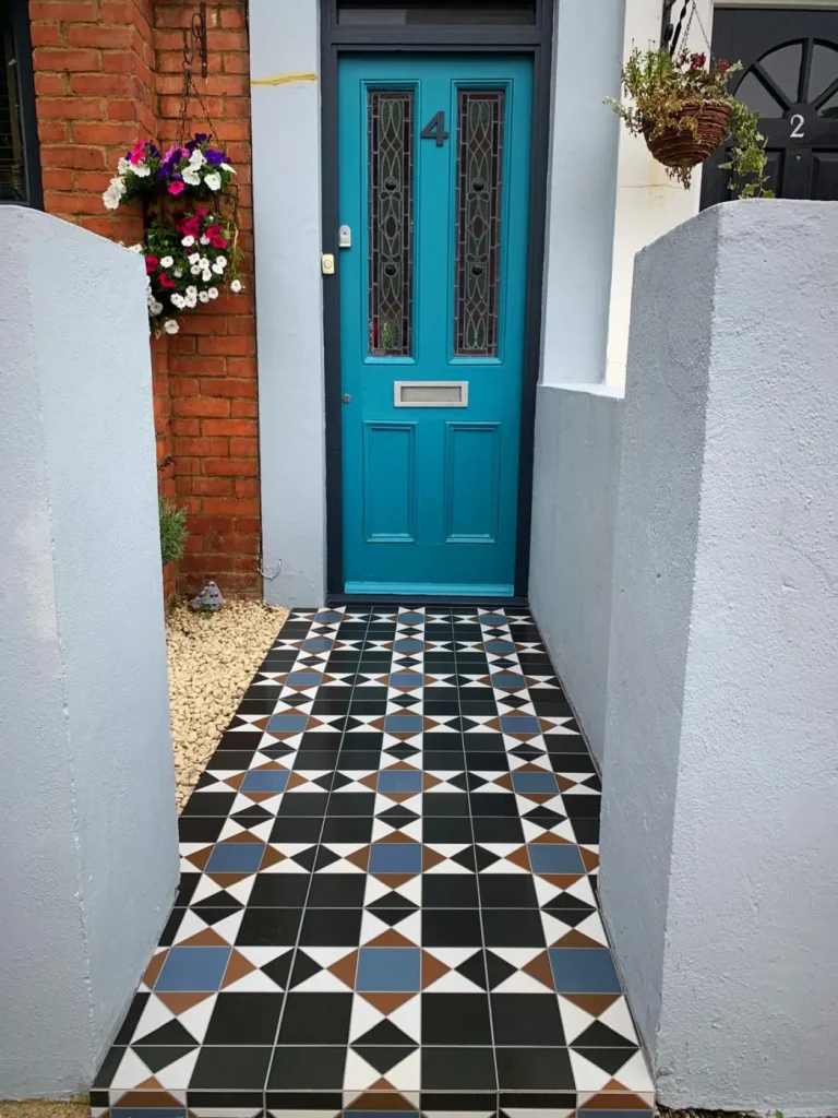 Geometric front path tiling beside a planted garden border at a period property