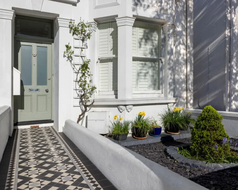 Victorian tiled front path with geometric pattern leading to a turquoise front door