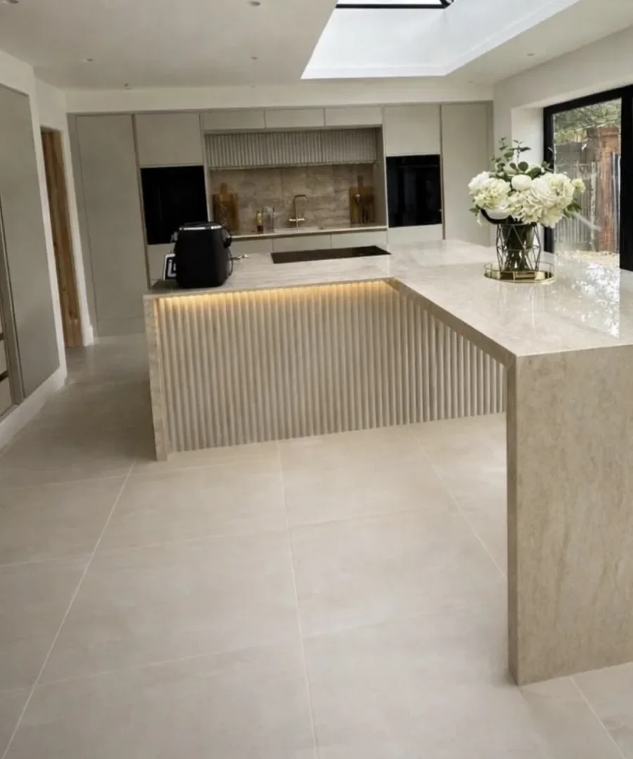 Contemporary kitchen tiling with fluted marble island, skylight and large format floor tiles