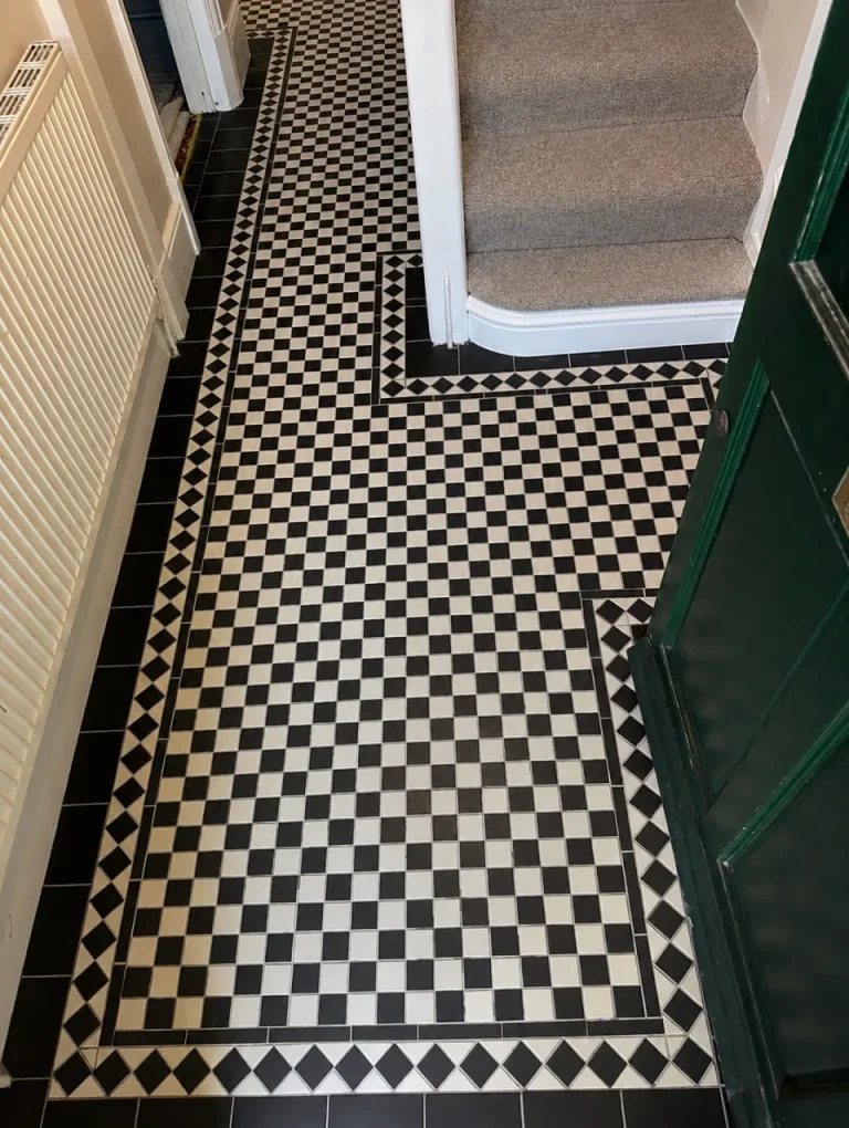 Black and white Victorian checkerboard tiled hallway with geometric border