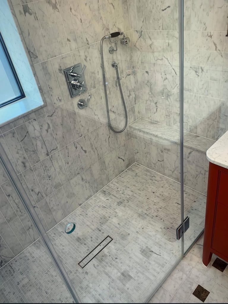 Marble wet room with mosaic floor, wall tiles and glass shower screen