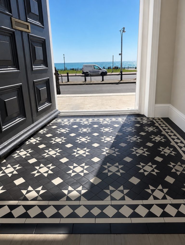 Geometric black and white tiled threshold with open doorway and sea view
