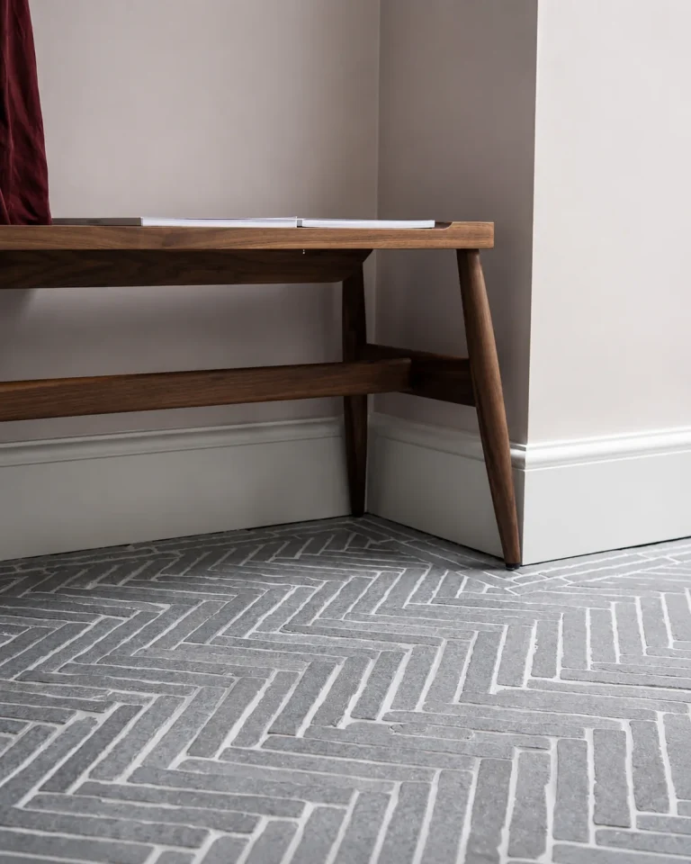 Close-up of grey herringbone limestone floor tiles in the Chiswick en-suite renovation.