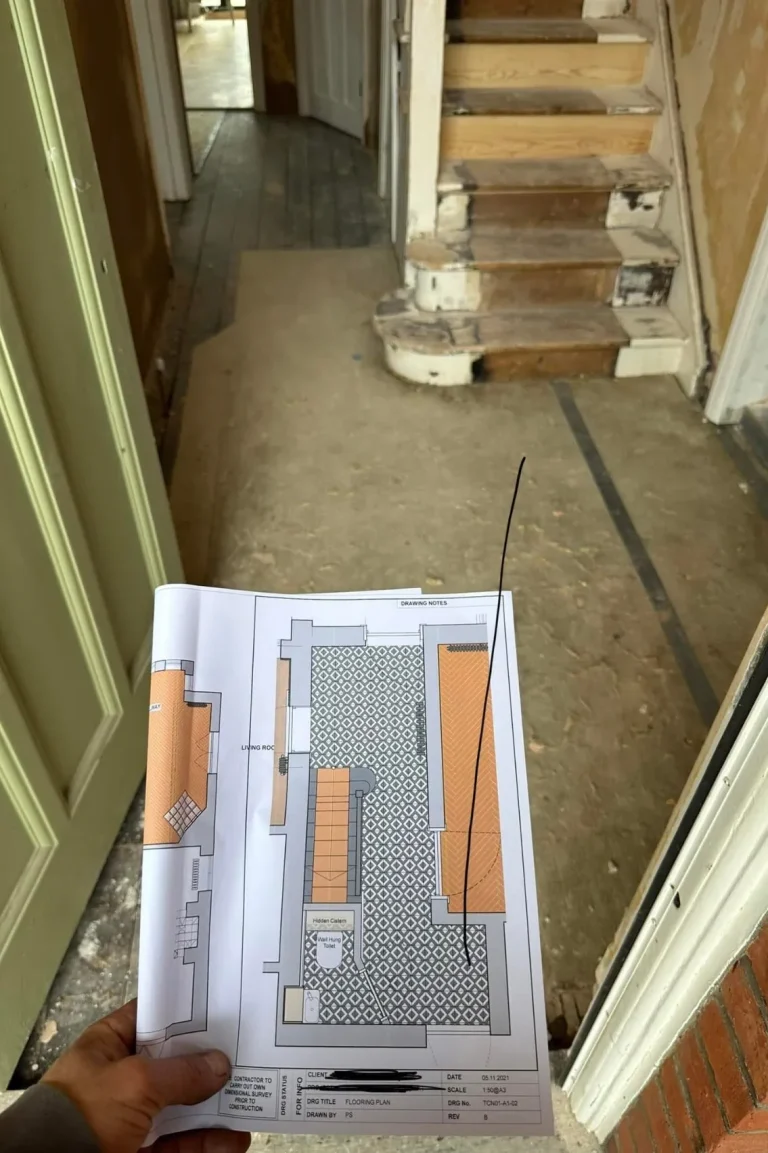 Finished Chiswick entrance hall with geometric tiled floor and carpeted stairs.