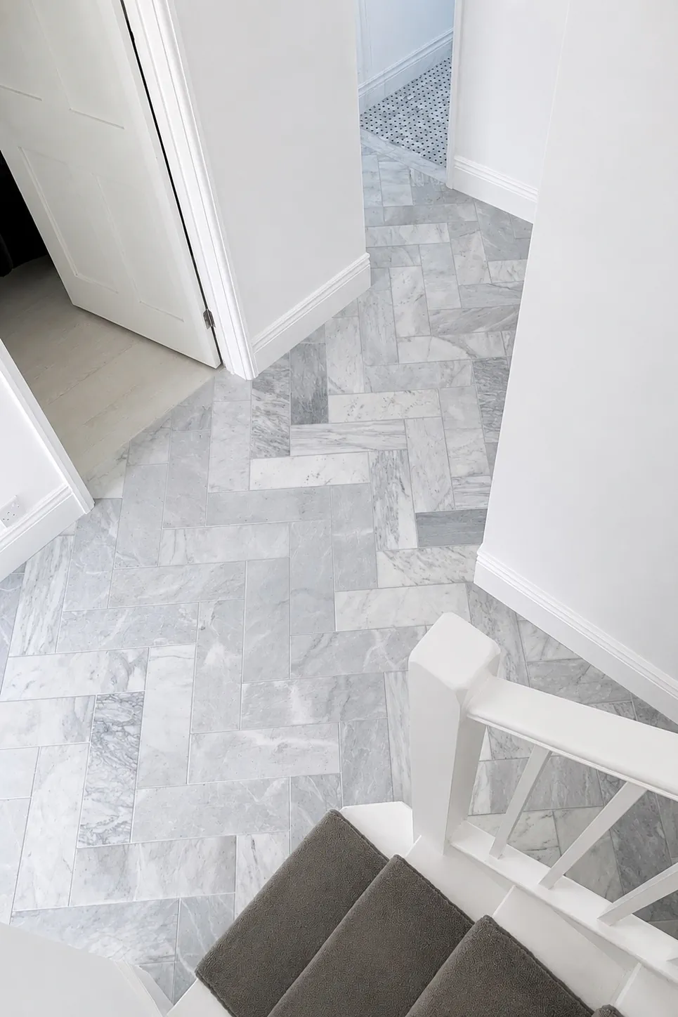 Finished Chiswick ground-floor marble herringbone tiled hallway.