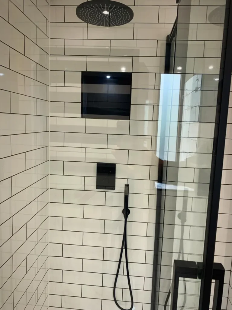 Surrey barn conversion bathroom during first fix with exposed timber frame and brick chimney breast