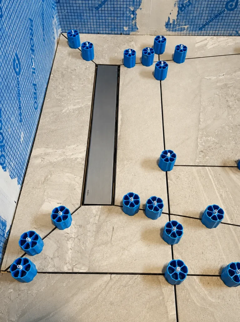 Linear shower drain and levelling spacers during Twickenham bathroom floor tile installation