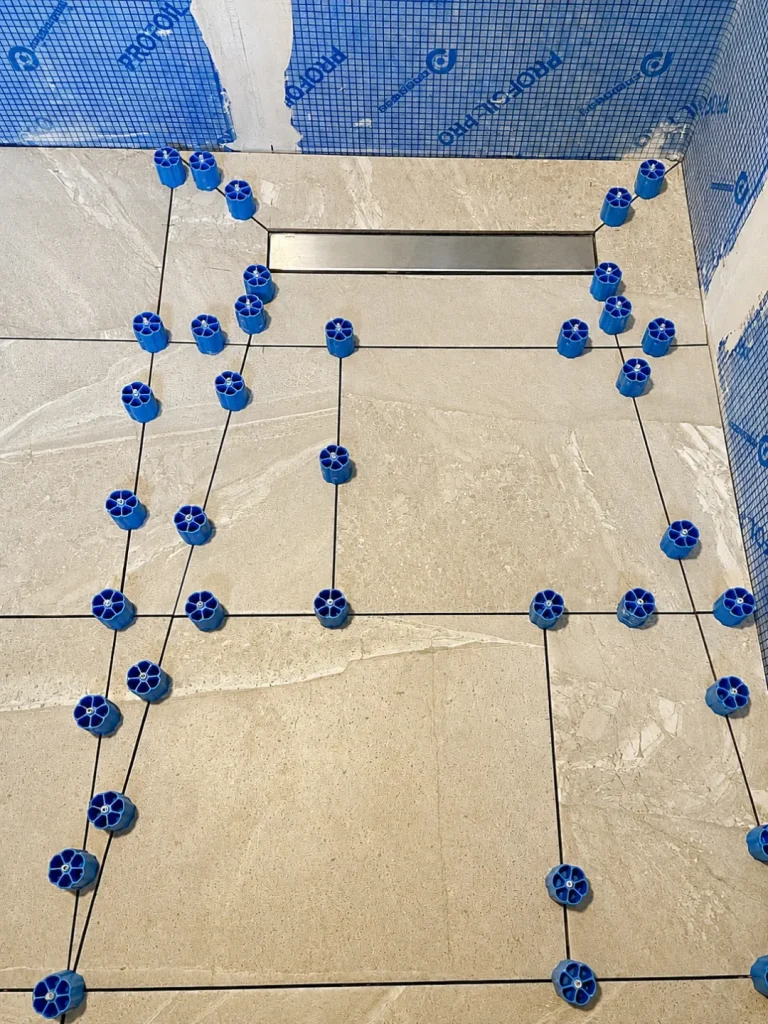 Shower floor tile levelling around a linear drain in a Twickenham bathroom renovation