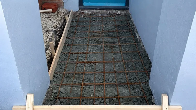 Front path base prepared with steel reinforcement mesh before porcelain tiles are installed.
