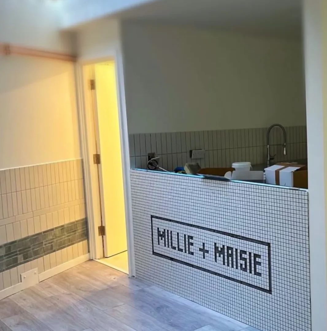 Commercial tiled counter at HILLIE+HOUSE with mosaic branding and tiled wall detail