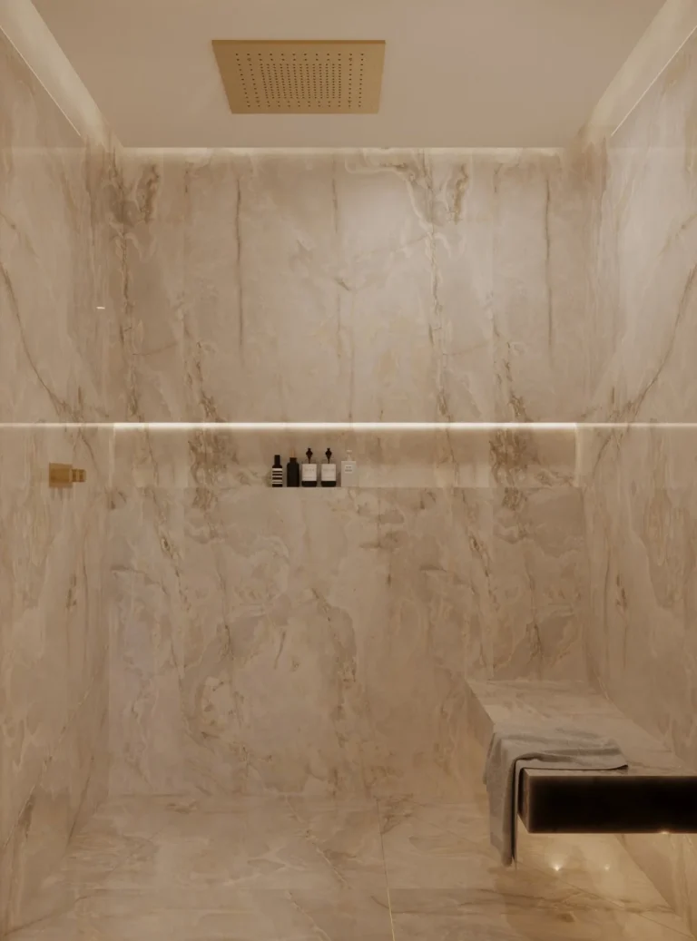 Walk-in shower lined with large-format marble-effect tiles and recessed LED shelf lighting