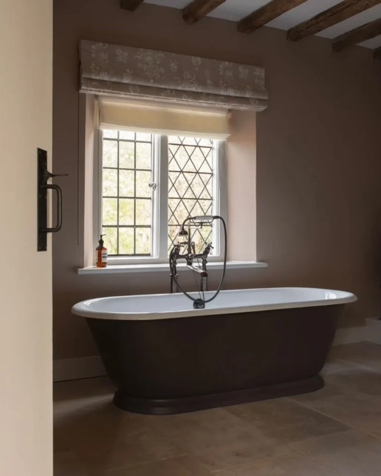 Period home bathroom with freestanding bath, leaded window and exposed ceiling beams