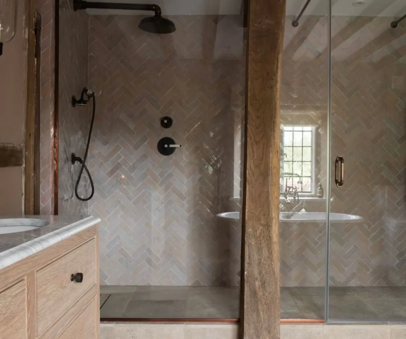 Period home bathroom with herringbone shower tiles, exposed timber beams and glass shower screen